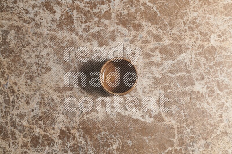 Top View Shot Of A Brown Pottery bowl On beige Marble Flooring