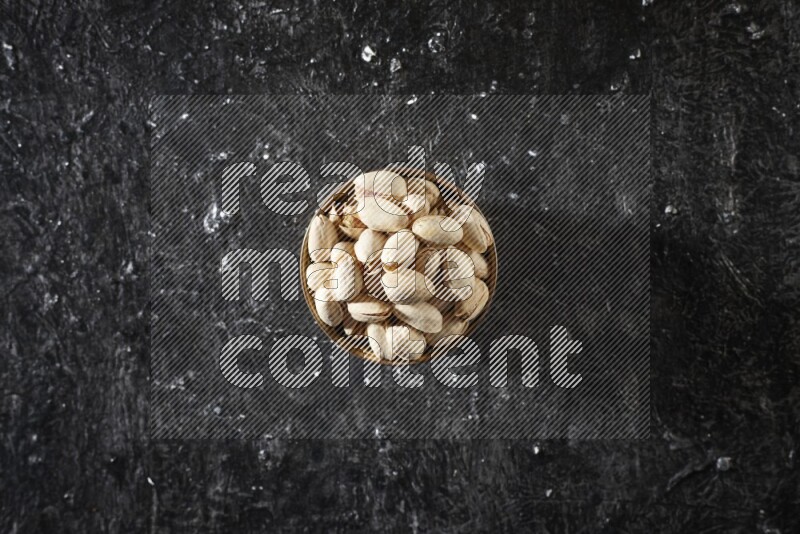 مكسرات في وعاء معدني علي خلفية سوداء