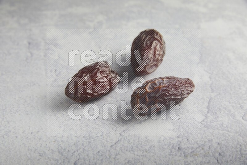 three madjoul dates on a light grey background
