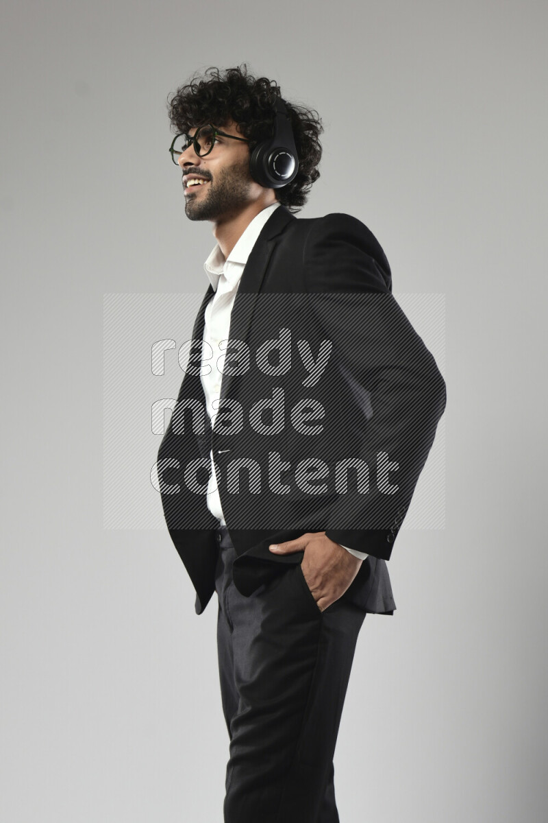 رجل يرتدي ملابس رسمية يضع سماعات رأس علي خلفية بيضاء