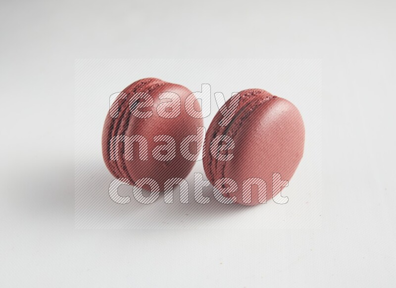 45º Shot of two Red Velvet macarons on white background