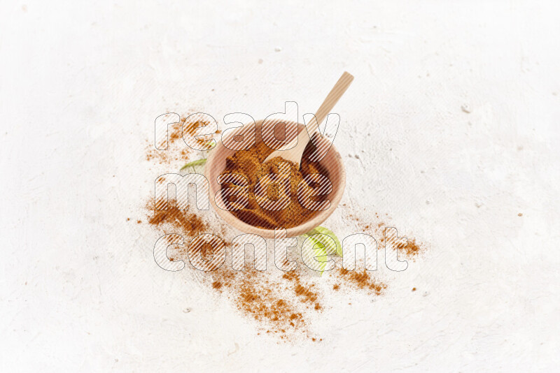A wooden bowl full of ground paprika powder on white background