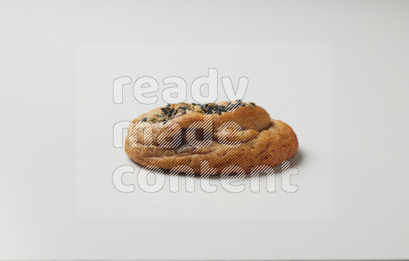 Hasawi cookie field with date and decorated by black seed and Anise grain on a white background