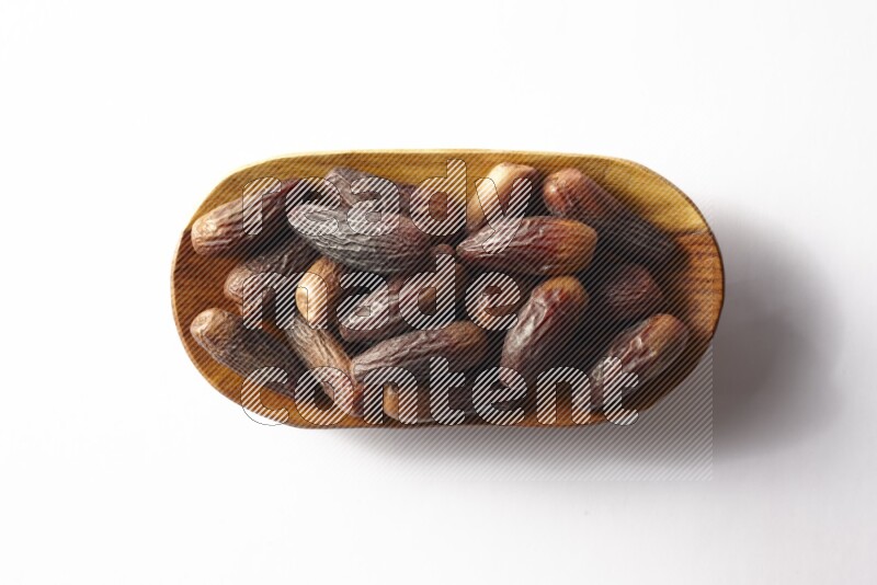 Dates in a wooden plate on white background