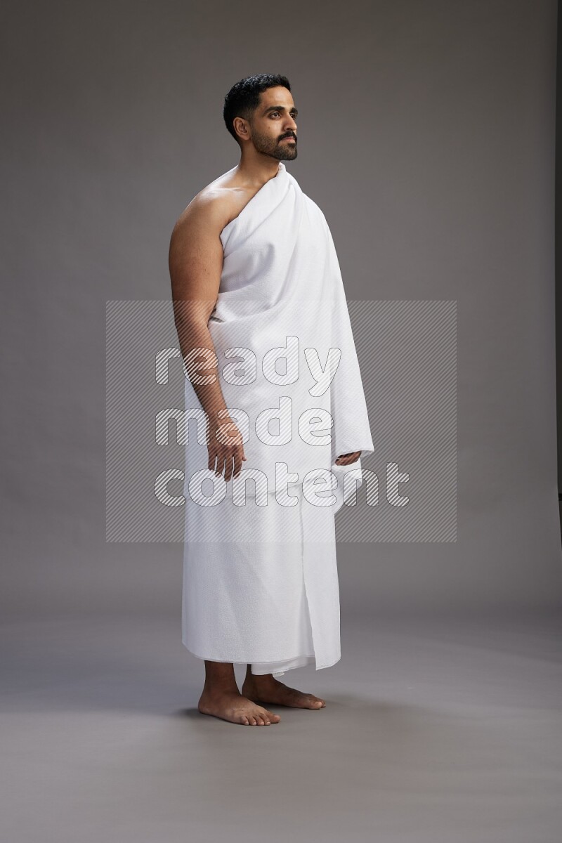 A man wearing Ehram Standing Interacting with the camera on gray background