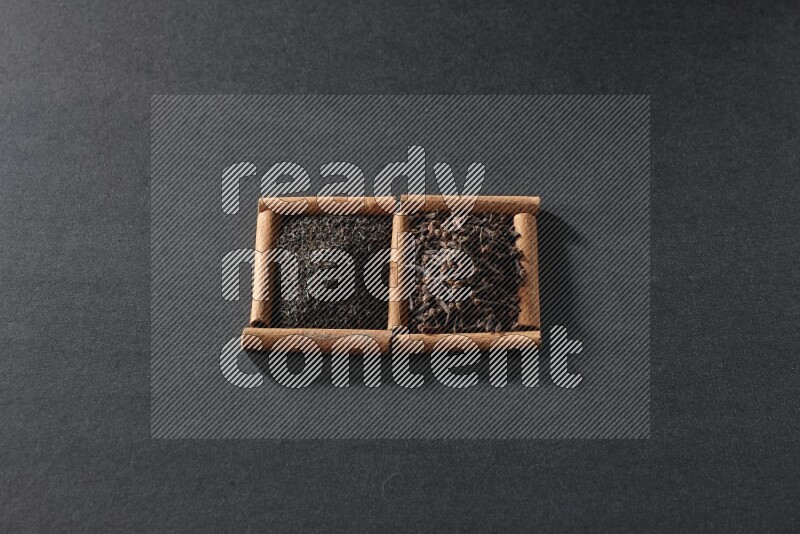 مربعان من أعواد القرفة ممتلئان بالشاي وحبوب القرنفل علي خلفية سوداء