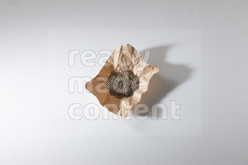 حبوب الكمون في قطعة من الورق علي خلفية بيضاء