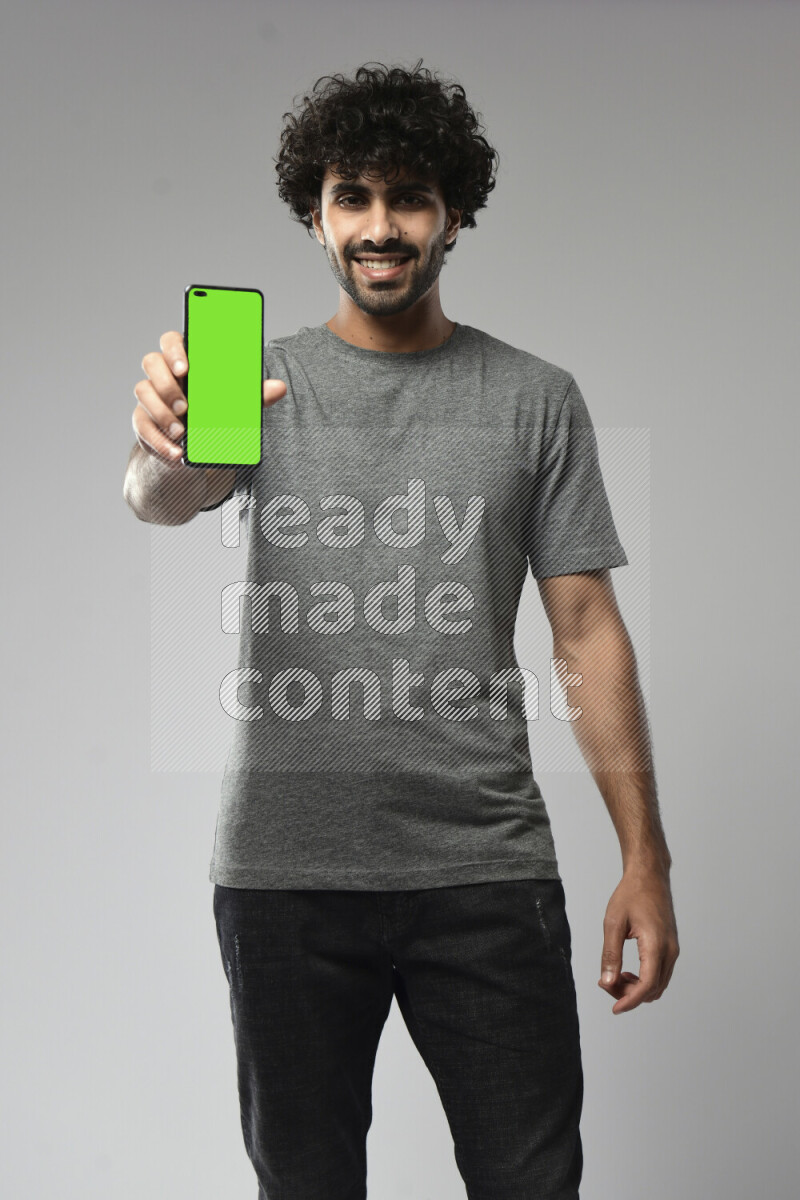 A man wearing casual standing and showing a phone screen on white background
