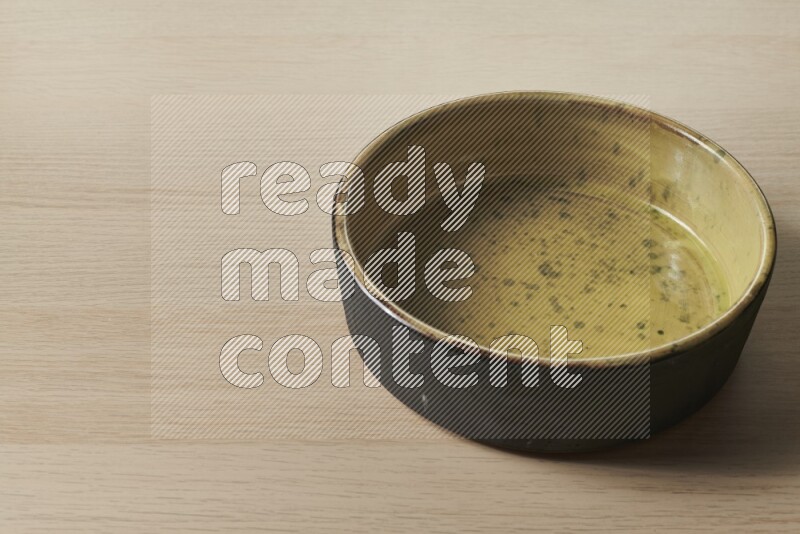 A multicolored pottery oven plate on light wooden background
