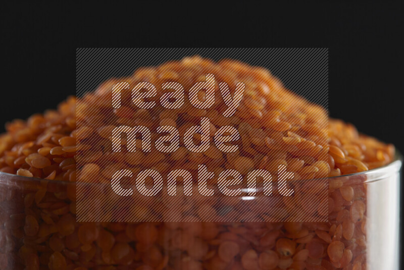 Lentils in a glass jar on black background