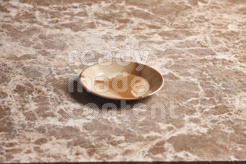 A multicolored pottery plate on beige marble background