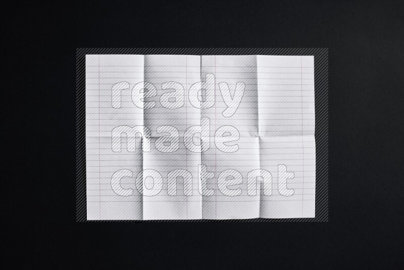 Folded notebook sheet on black background