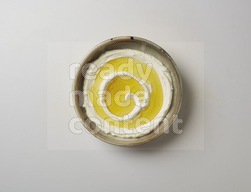 Lebnah garnished with olive oil in a grey pottery plate on a white background