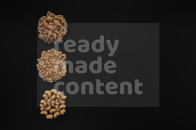 Different pasta types in 3 bunches on black background