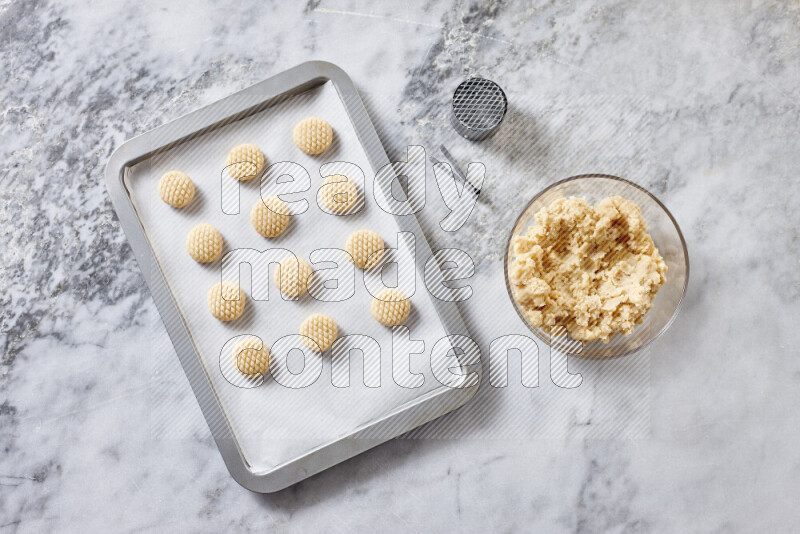 Kahk step by step with its ingredients ghee, sugar, flour, sesame, yeast, water and kahk flavor on grey marble background