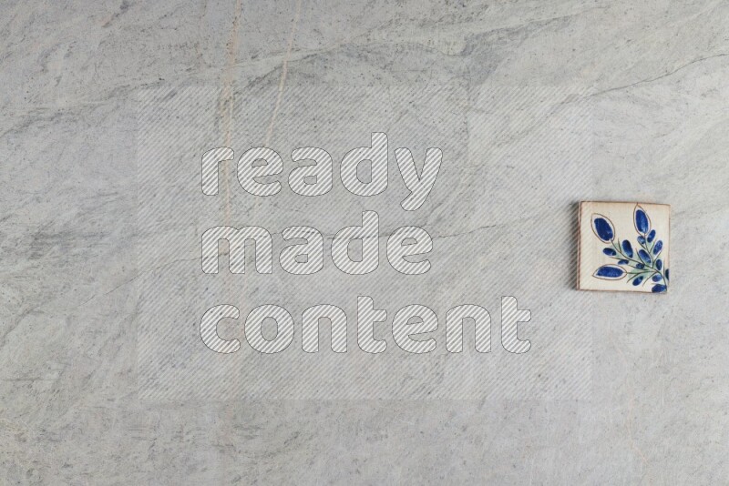 A decorative pottery coaster on grey marble background