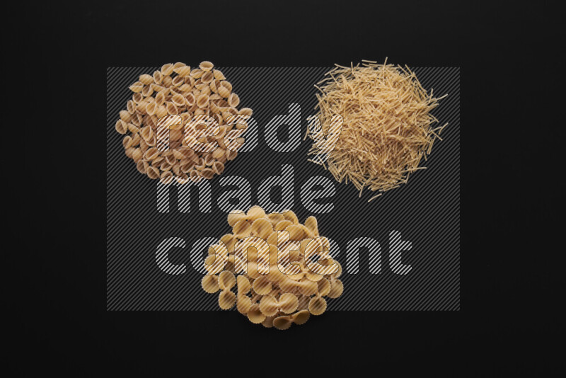 Different pasta types in bunches on black background