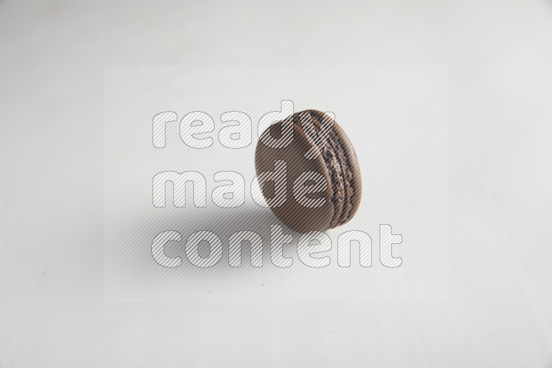 45º Shot of Brown Dark Chocolate macaron on white background