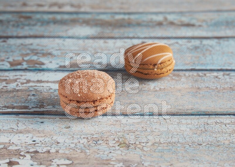 45º Shot of of two assorted Brown Irish Cream, and Brown Hazelnuts macarons  on light blue background