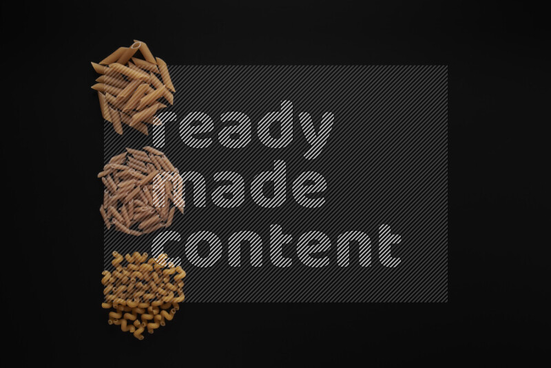Different pasta types in 3 bunches on black background