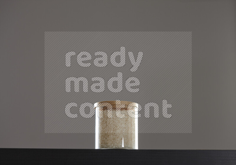 White rice in a glass jar on black background
