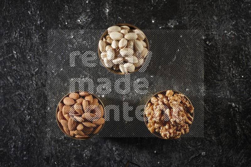 Nuts in a metal bowl in a dark setup