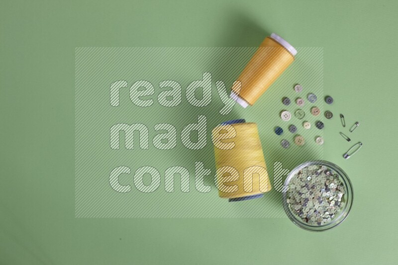 A collection of sewing and tailoring tools arranged on a green background