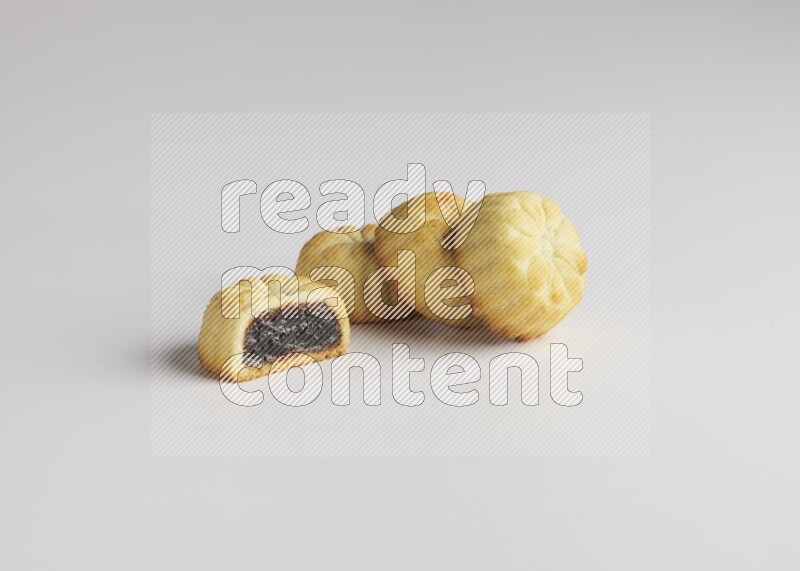 Four Pieces of Maamoul filled with date one of them is cut direct on white background