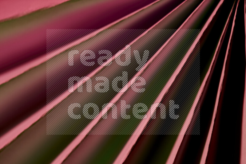 An image presenting an abstract paper pattern of lines in green and pink tones