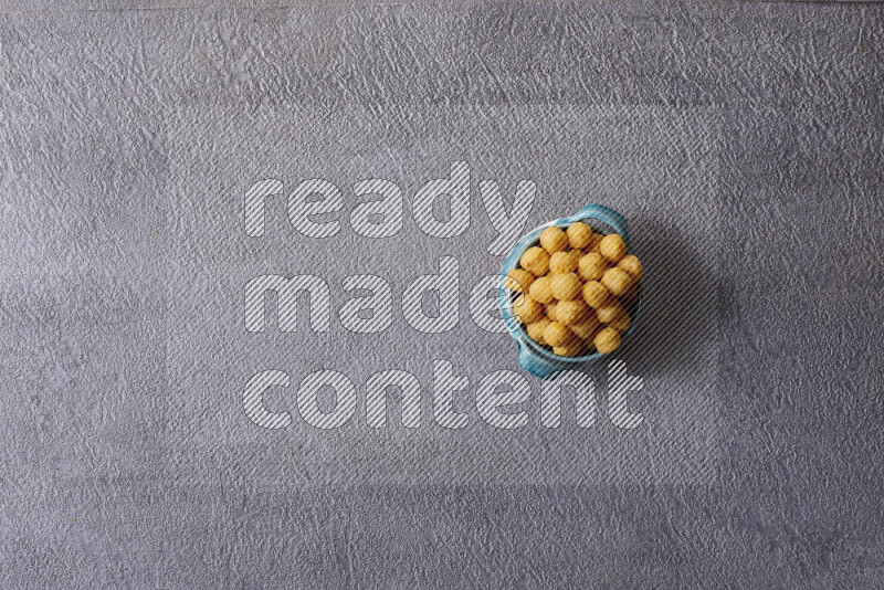 Assorted snacks in pottery bowls on grey background
