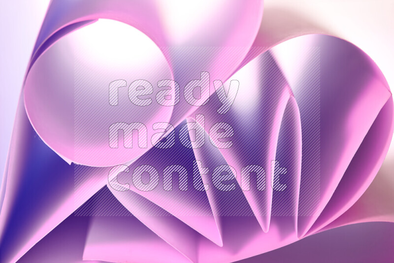 An artistic display of paper folds creating a harmonious blend of geometric shapes, highlighted by soft lighting in purple tones