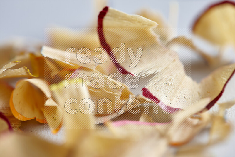 A close-up showing a small pile of pencil shavings with varied color edges on grey background