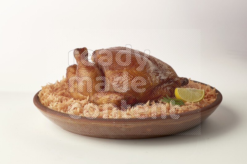 red basmati Rice with whole roasted chicken on a pottery plate direct on white background