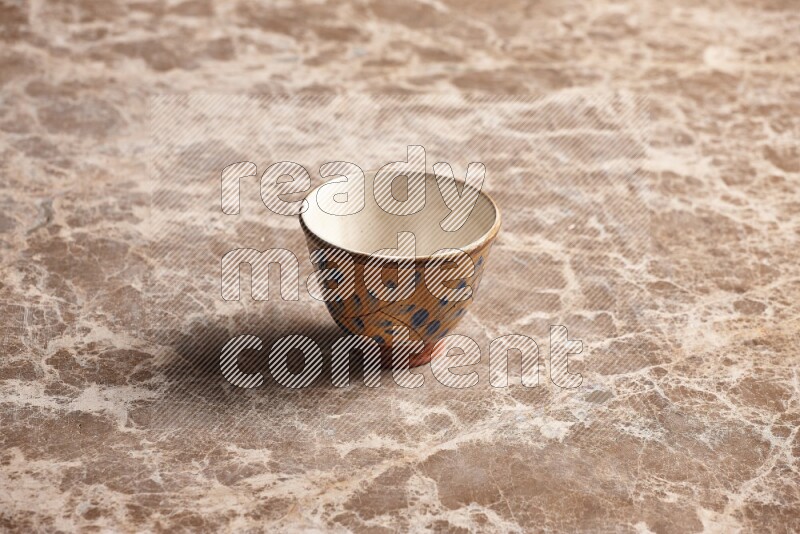 A decorative pottery bowl on beige marble background