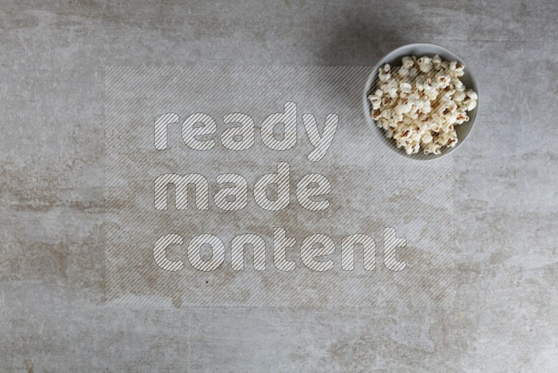 popcorn in gray bowl on a grey textured countertop