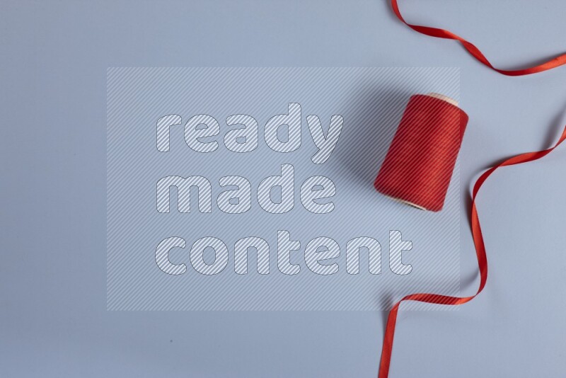 A red collection of sewing and tailoring tools arranged on a blue background