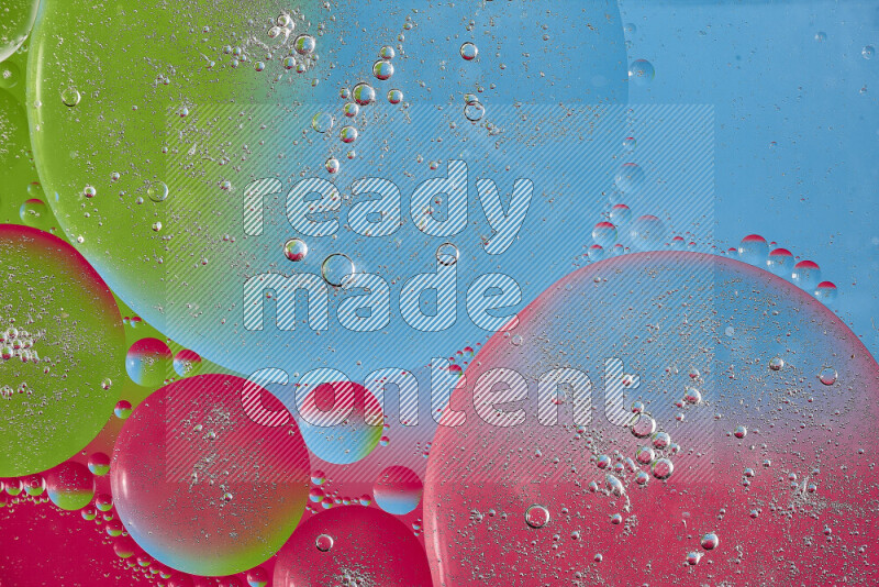 Close-ups of abstract oil bubbles on water surface in shades of pink, green and blue