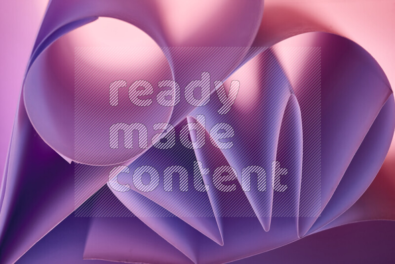 An artistic display of paper folds creating a harmonious blend of geometric shapes, highlighted by soft lighting in purple tones
