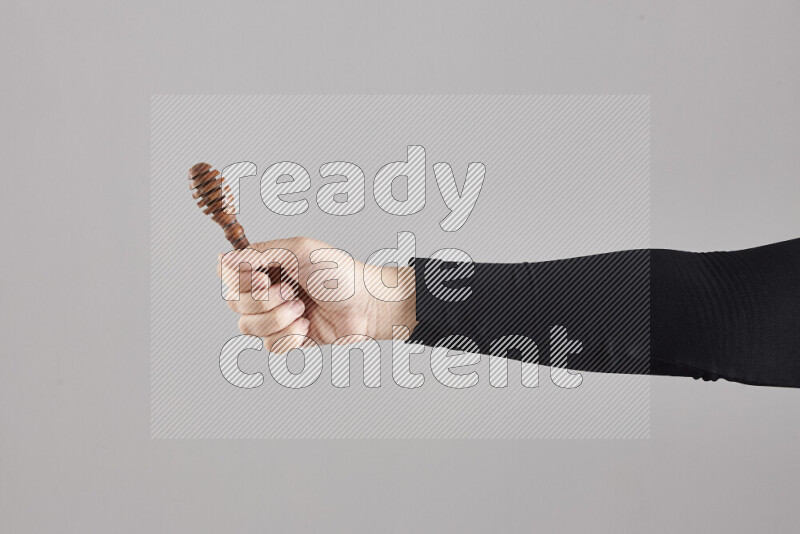 A woman in black abaya holding different wooden essentials in different positions