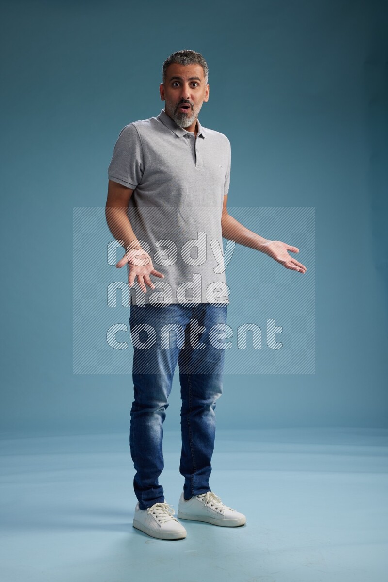 Man Standing Interacting with the camera on blue background