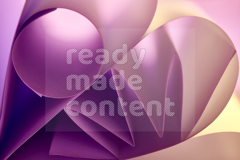 عرض فني لطيات الورق تخلق مزيج من الأشكال الهندسية، مضاءة بإضاءة ناعمة بدرجات اللون الارجواني والالوان الدافئة