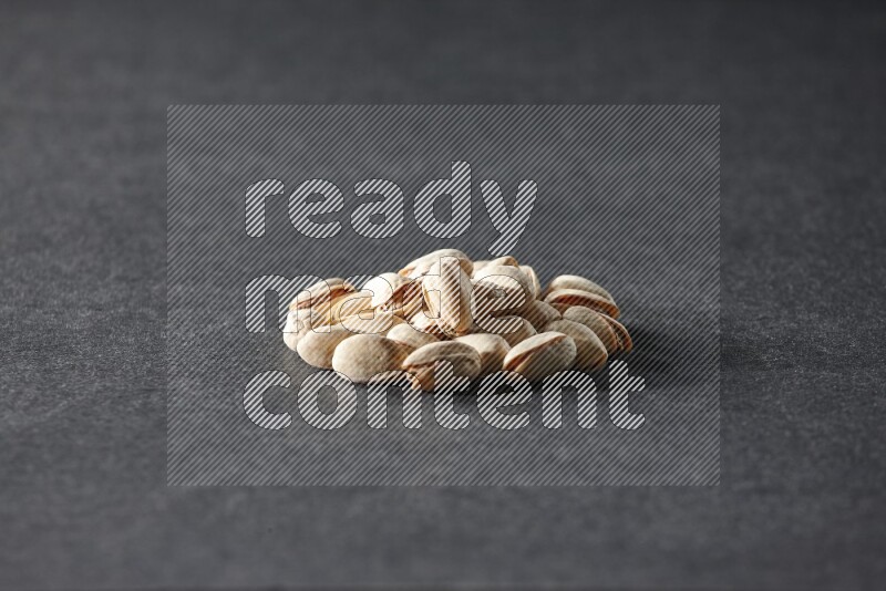 A bunch of pistachios on a black background in different angles