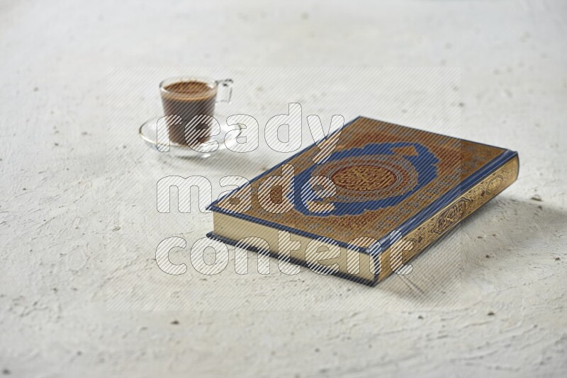 Quran with dates, prayer beads and different drinks all placed on textured white background