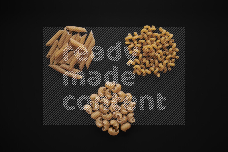 Different pasta types in bunches on black background