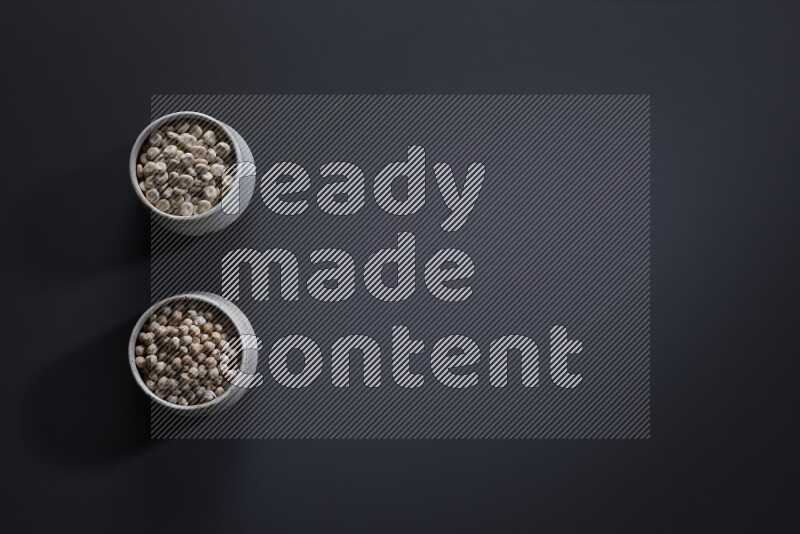 Legumes in pottery bowls on grey background