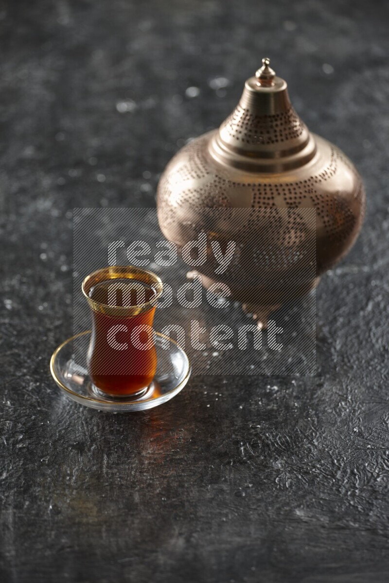 A golden lantern with different drinks, dates, nuts, prayer beads and quran on textured black background