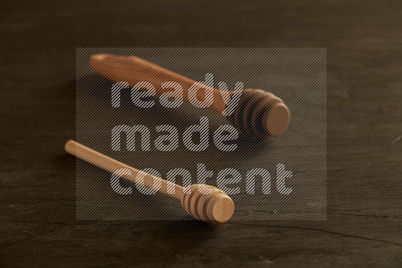 Wooden honey dipper on black slate background