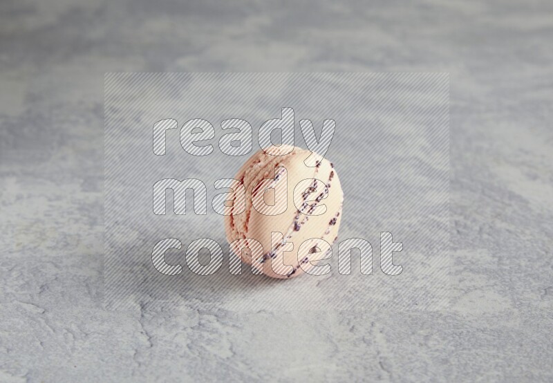 45º Shot of pink orange blossom macaron on white  marble background