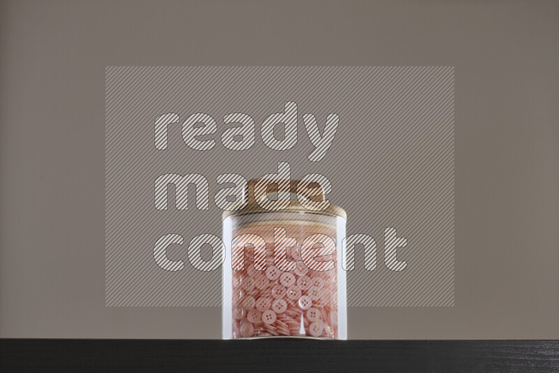 Buttons in a glass jar on black background