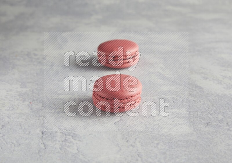 45º Shot of two Pink Raspberry macarons  on white  marble background